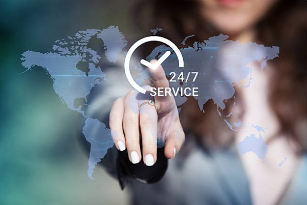 Businesswoman pressing 24/7 support service button on world map on touch screen. Customer service concept.